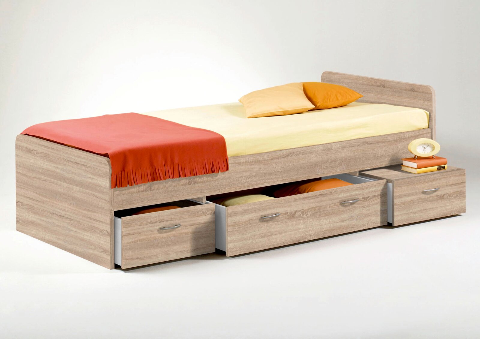 Jugendbett aus Holz mit drei Schubladen, gelber Bettwäsche und orangen Kissen, seitliche Perspektive