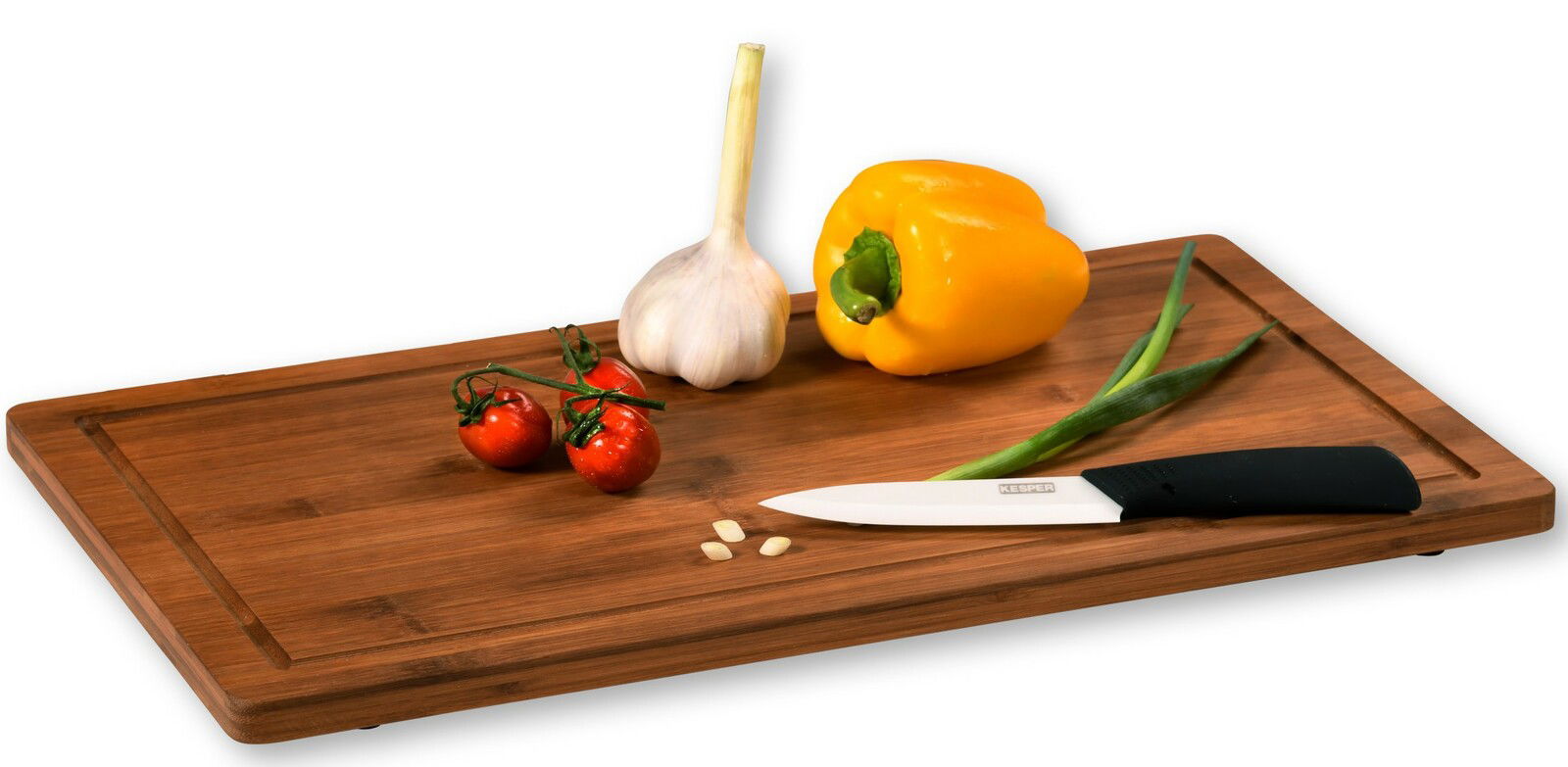 Holz-Schneidebrett mit gelber Paprika, Knoblauch, Tomaten und Messer, seitliche Perspektive