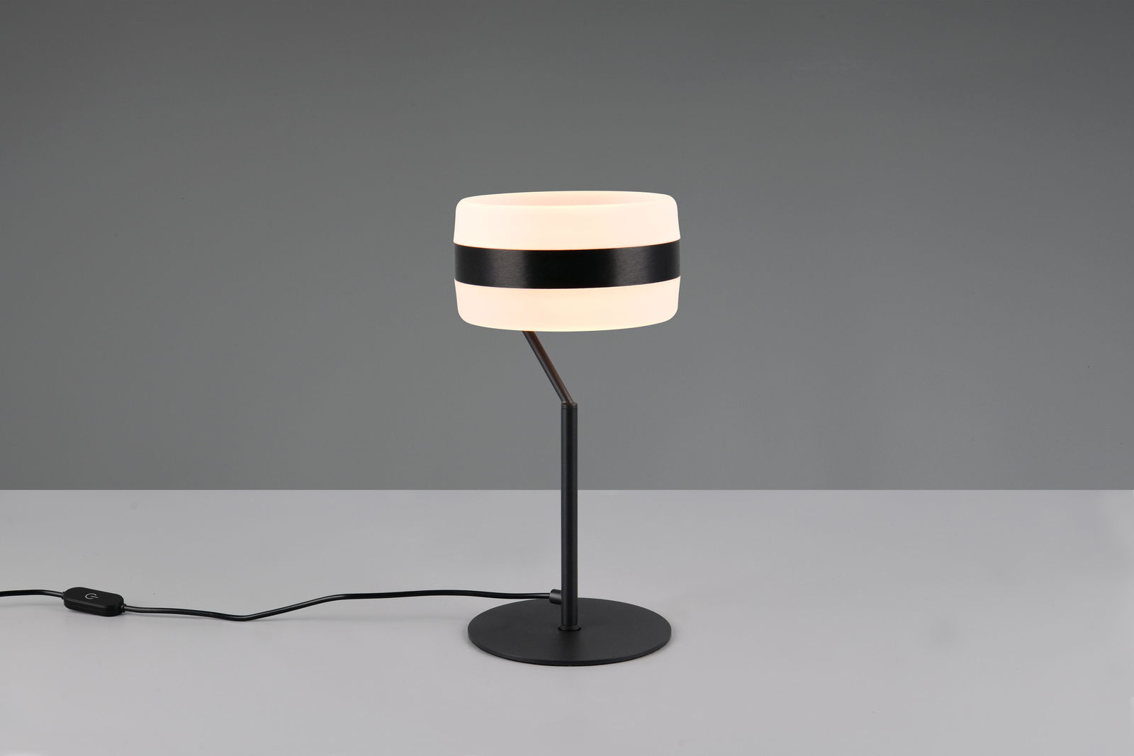 Moderne Tischleuchte mit rundem, zweifarbigem Lampenschirm und schlankem, schwarzem Ständer, seitliche Perspektive