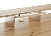Nahaufnahme eines Gaming-Schreibtisches aus Holz mit Kabeldurchführung und Ablagefach, seitliche Perspektive.