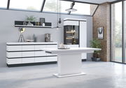 Moderner Wohnbereich mit Esstisch im Vordergrund, Sideboard und Vitrine im Hintergrund, seitliche Perspektive.