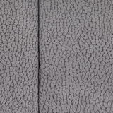 Nahaufnahme der grauen, strukturierten Oberfläche eines Chefsessels.