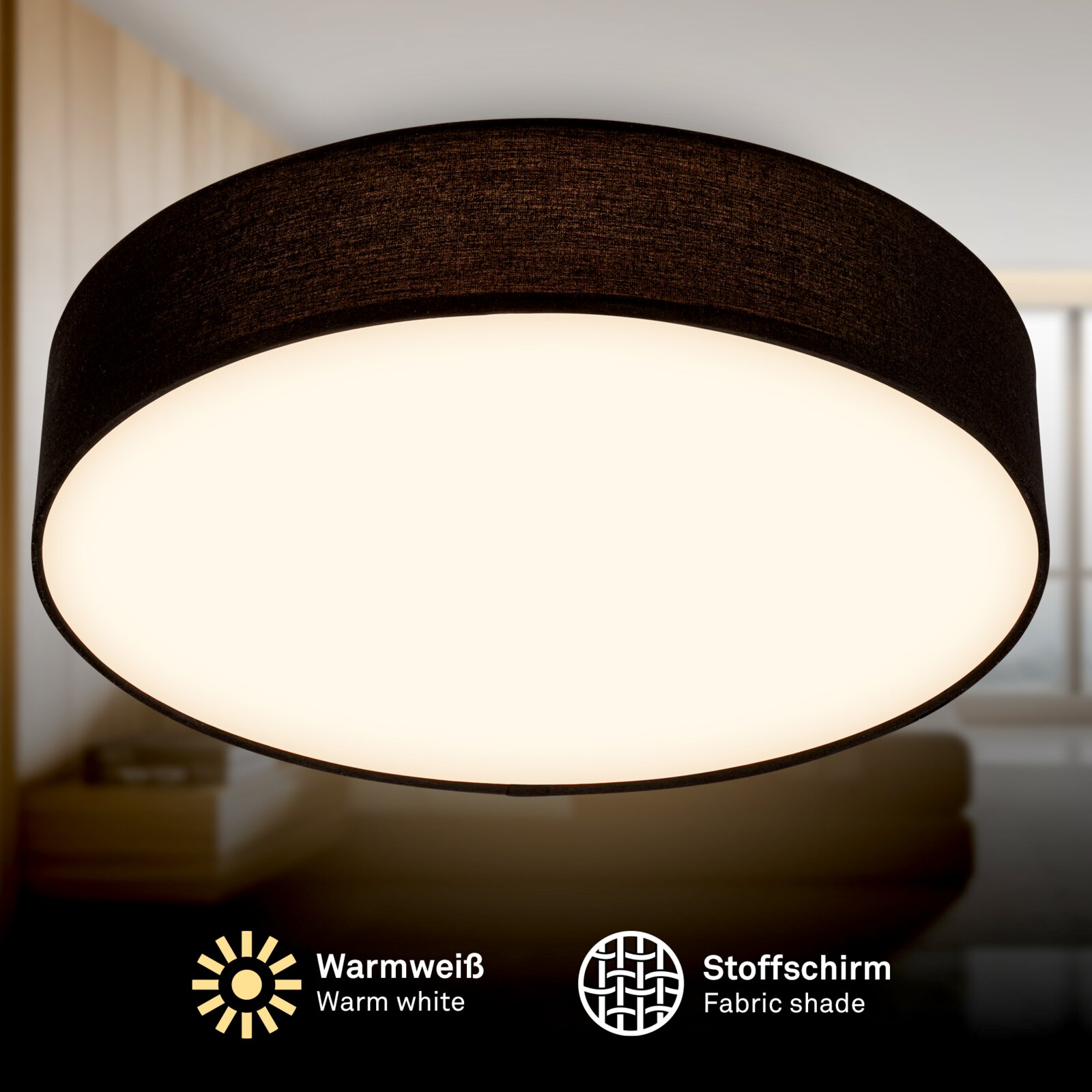 Schwarze Deckenleuchte mit Stoffschirm und warmweißem Licht, Nahaufnahme von unten auf die leuchtende Unterseite in einem Wohnraum