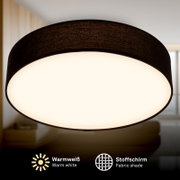 Schwarze Deckenleuchte mit Stoffschirm und warmweißem Licht, Nahaufnahme von unten auf die leuchtende Unterseite in einem Wohnraum