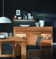 Hochwertiges Highboard aus Holz in einem modernen Esszimmer, frontal betrachtet, mit dekorativen Elementen und Beleuchtung.