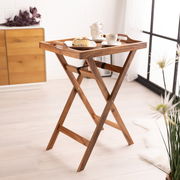 Holz-Serviertablett mit Standfuß, seitliche Perspektive, dekoriert mit Tassen und einem Stück Kuchen, in einem hellen Raum mit Holzboden.