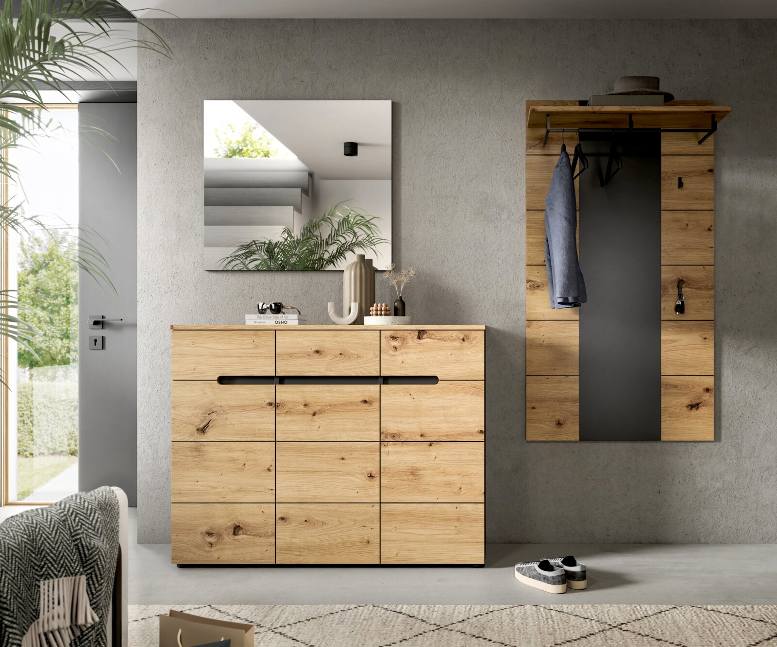 Modernes Garderoben-Set im Flur mit Holz-Kommode und Wandgarderobe mit schwarzer Rückwand, Kleiderhaken und Ablage, darüber quadratischer Wandspiegel; Frontalansicht.