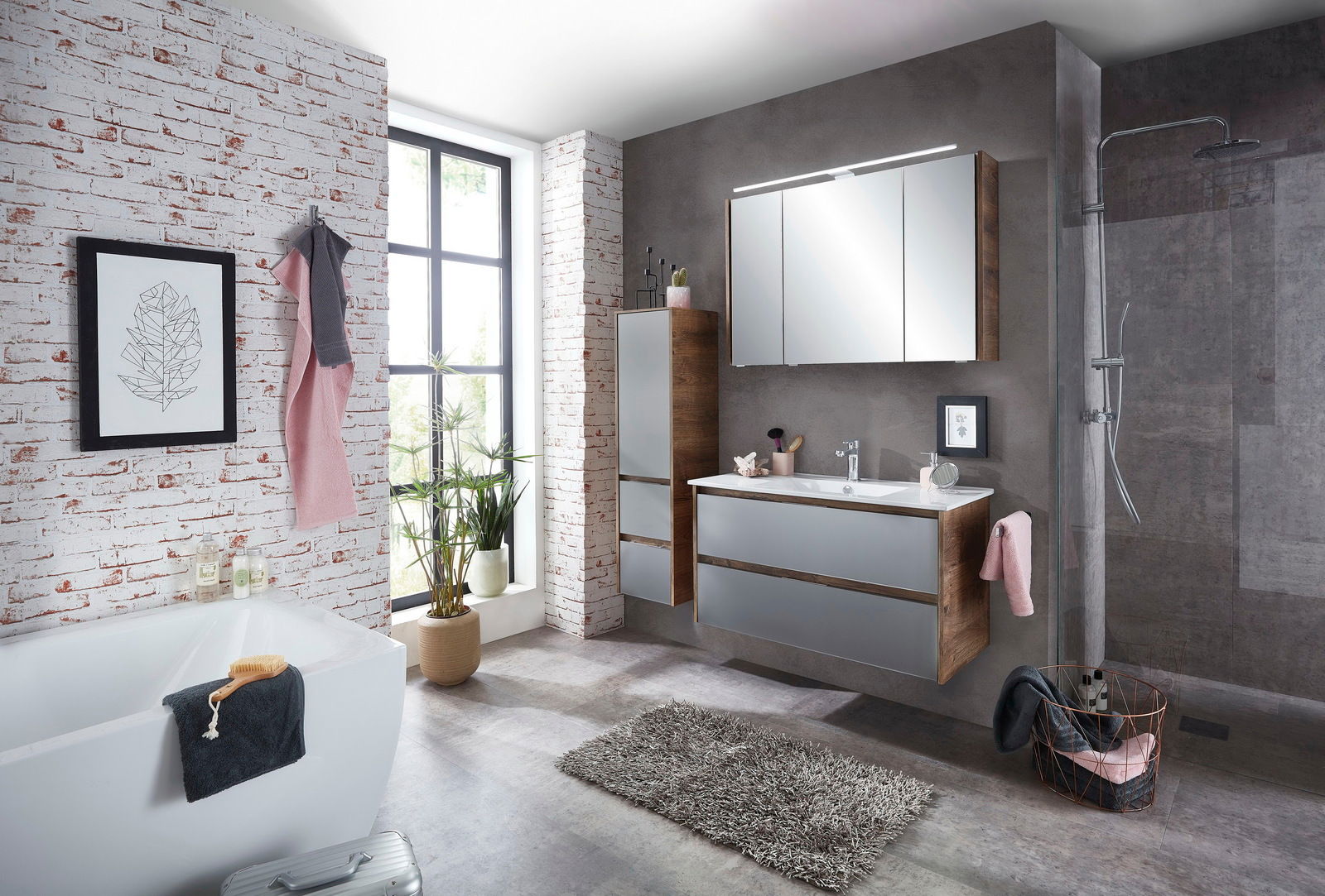 Sadena Midischrank LANDAU Modernes Badezimmer mit Midischrank in Holzoptik, grauen Fronten und Spiegel, seitliche Perspektive.