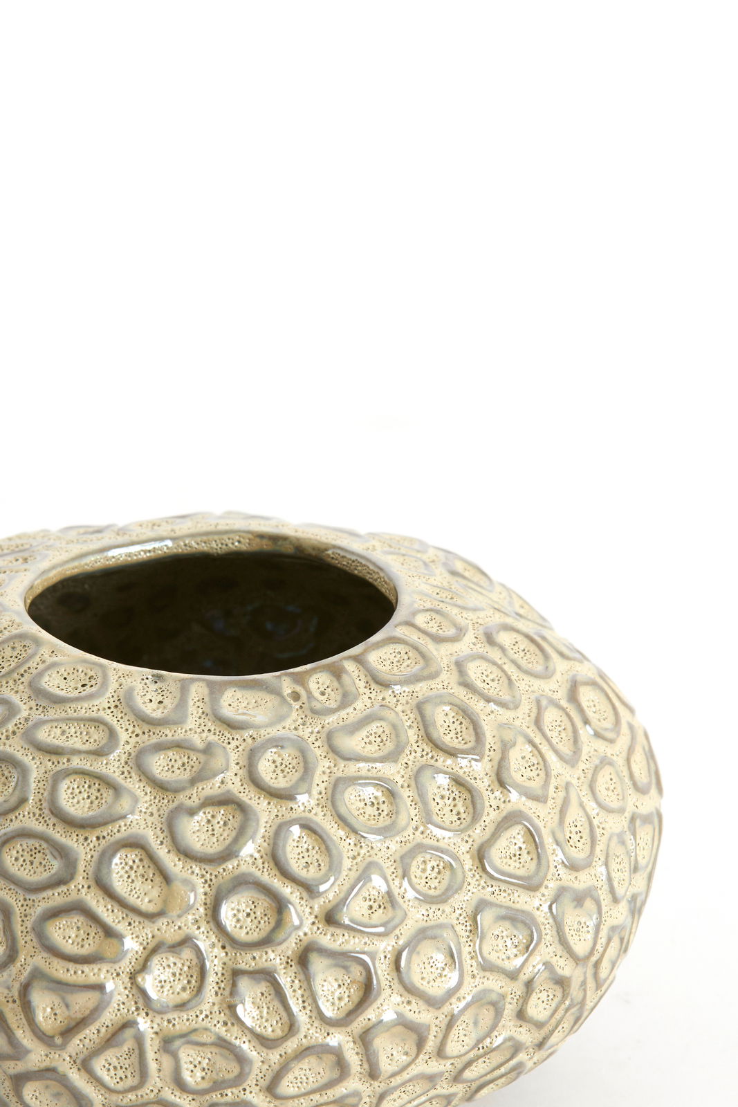 Nahaufnahme eines dekorativen Teelichthalters mit strukturierter Oberfläche in beige, von oben betrachtet.