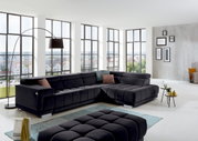 Modernes Ecksofa in dunklem Stoff in einem hellen Wohnzimmer mit großen Fenstern, seitliche Perspektive.