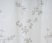 Nahaufnahme eines weißen Vorhangs mit grauem Blattmuster, Perspektive von vorne