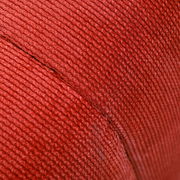 Nahaufnahme eines roten, gerippten Stoffes, vermutlich Teil eines Hockers, aus seitlicher Perspektive.