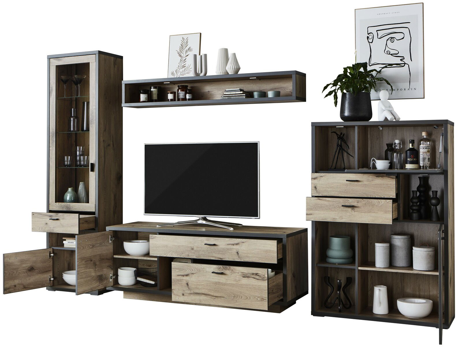 Frontale Ansicht der Wandkombination Zurbrüggen ORLANDO mit Holzoptik, bestehend aus einem TV-Element, einem hohen Schrank mit Glastür und einem Regal mit Schubladen, dekoriert mit Geschirr und Pflanzen.