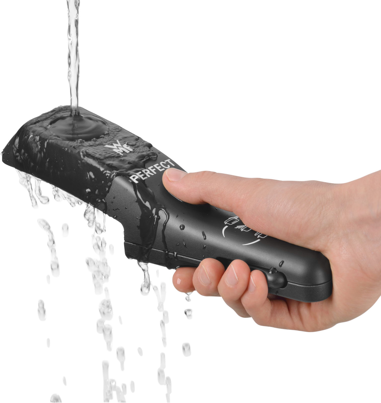 Hand hält einen schwarzen Griff eines Schnelltopfs, während Wasser darüber fließt, seitliche Perspektive