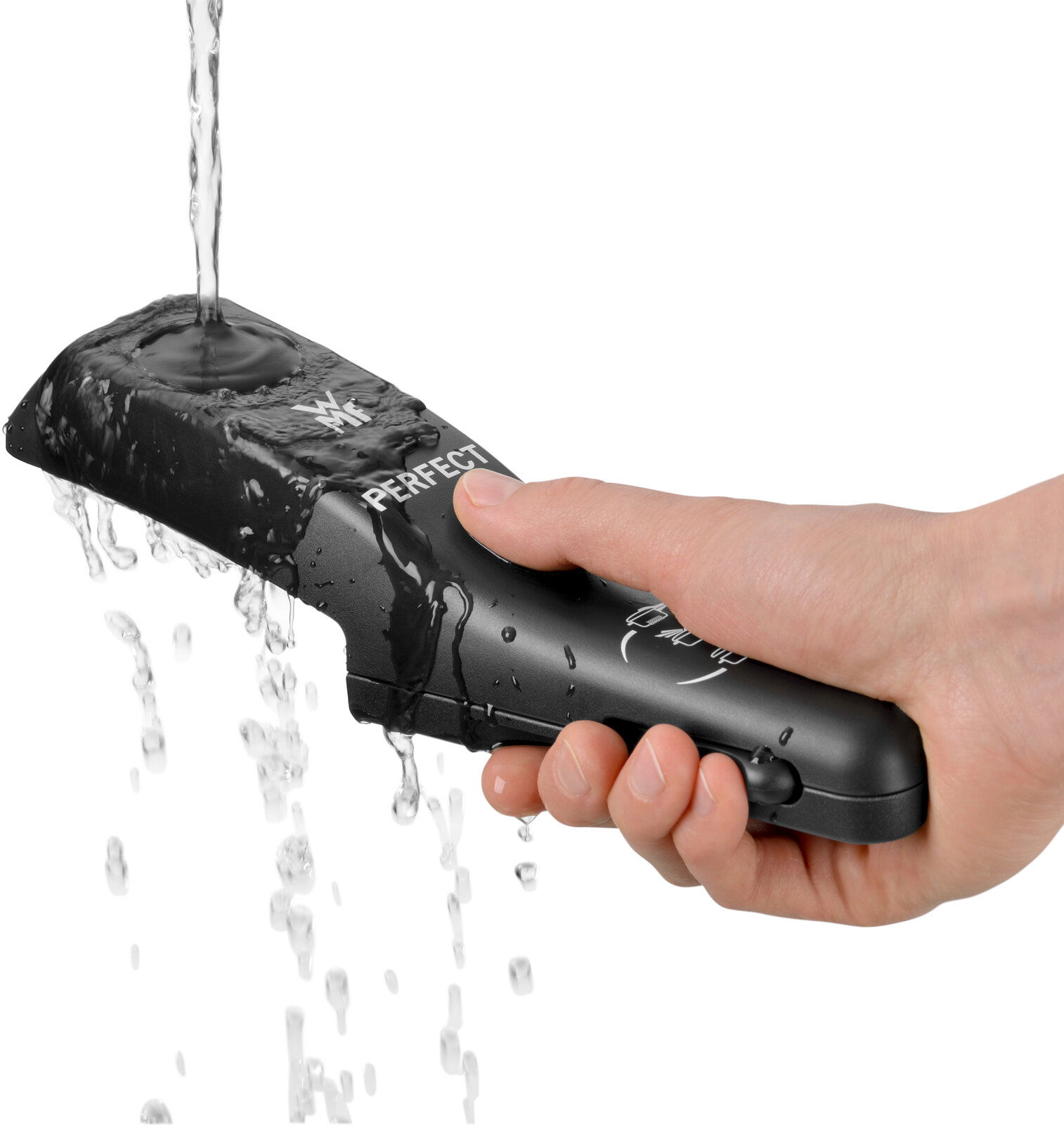 Hand hält einen schwarzen Griff eines Schnelltopfs, während Wasser darüber fließt, seitliche Perspektive