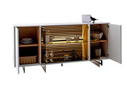 Modernes Sideboard mit offenen Türen, das von vorne gezeigt wird. Es hat eine weiße Außenseite, Holzelemente im Inneren und integrierte Beleuchtung. Dekorative Gegenstände wie Geschirr und Gläser sind sichtbar.