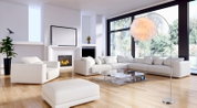 Moderne Bogen-Stehlampe mit großem, federähnlichem Lampenschirm in Cremeweiß auf Metallfuß, gezeigt aus leicht seitlicher Perspektive im hellen Wohnzimmer neben weißem Sofa und Glas-Couchtisch