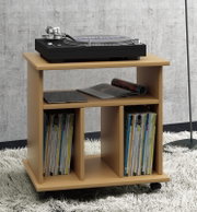 Rollbarer Beistell- und Plattenspielerwagen aus hellem Holz mit zwei offenen Fächern für Schallplatten und Bücher, oben ein schwarzer Plattenspieler; perspektivische Ansicht schräg von vorn.