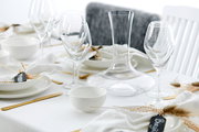 Elegante Tischdekoration mit der Servierschale Skagen 20cm, umgeben von Weingläsern und Besteck auf einem festlich gedeckten Tisch, seitliche Perspektive.