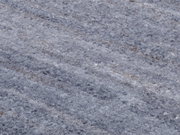 Nahaufnahme eines grauen Wollteppichs mit flauschiger Textur, von oben betrachtet.