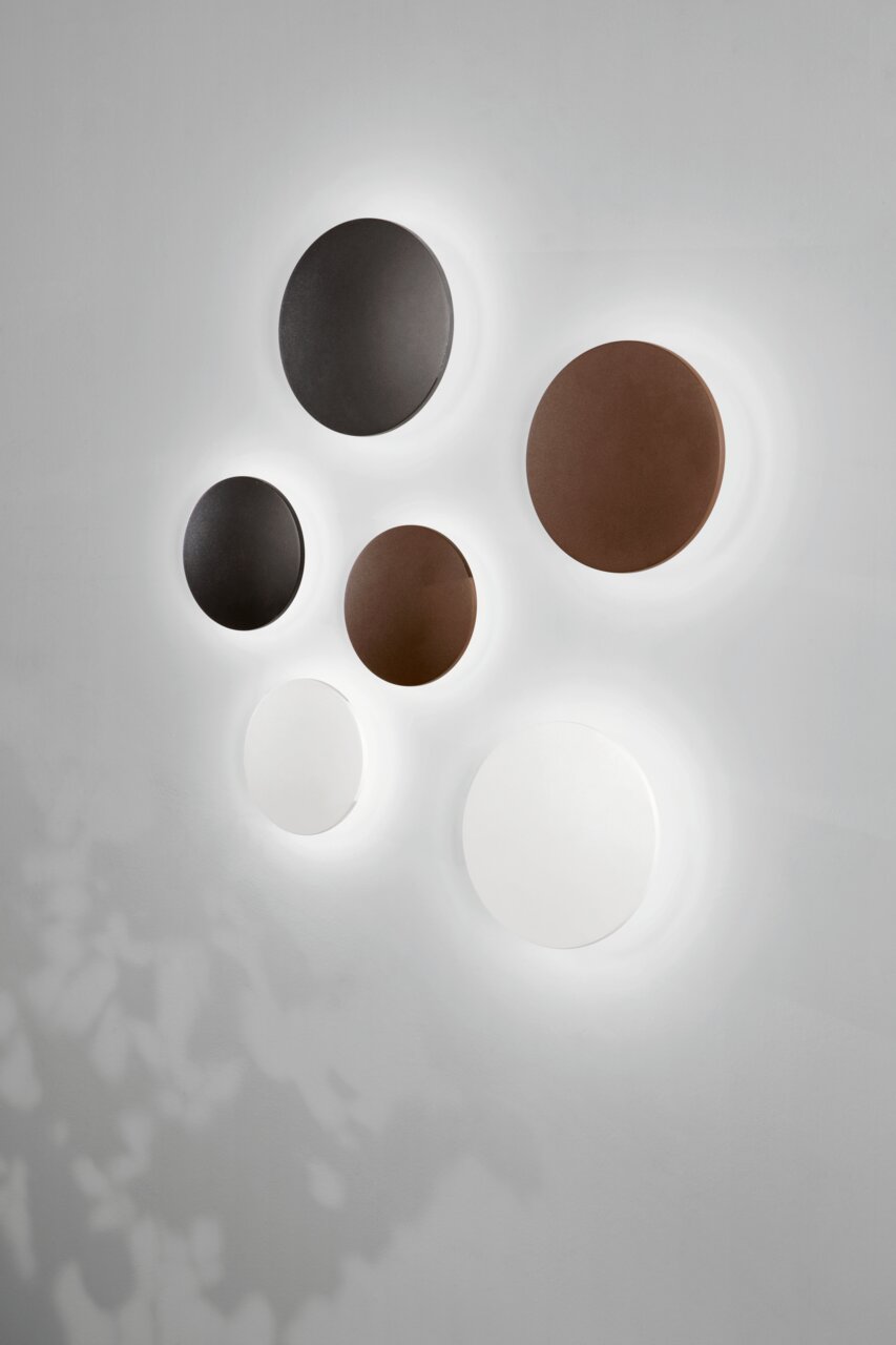 LED-Außenwandleuchten in verschiedenen Farben und Größen, an einer Wand montiert, mit leuchtendem Halo-Effekt. Perspektive von vorne.