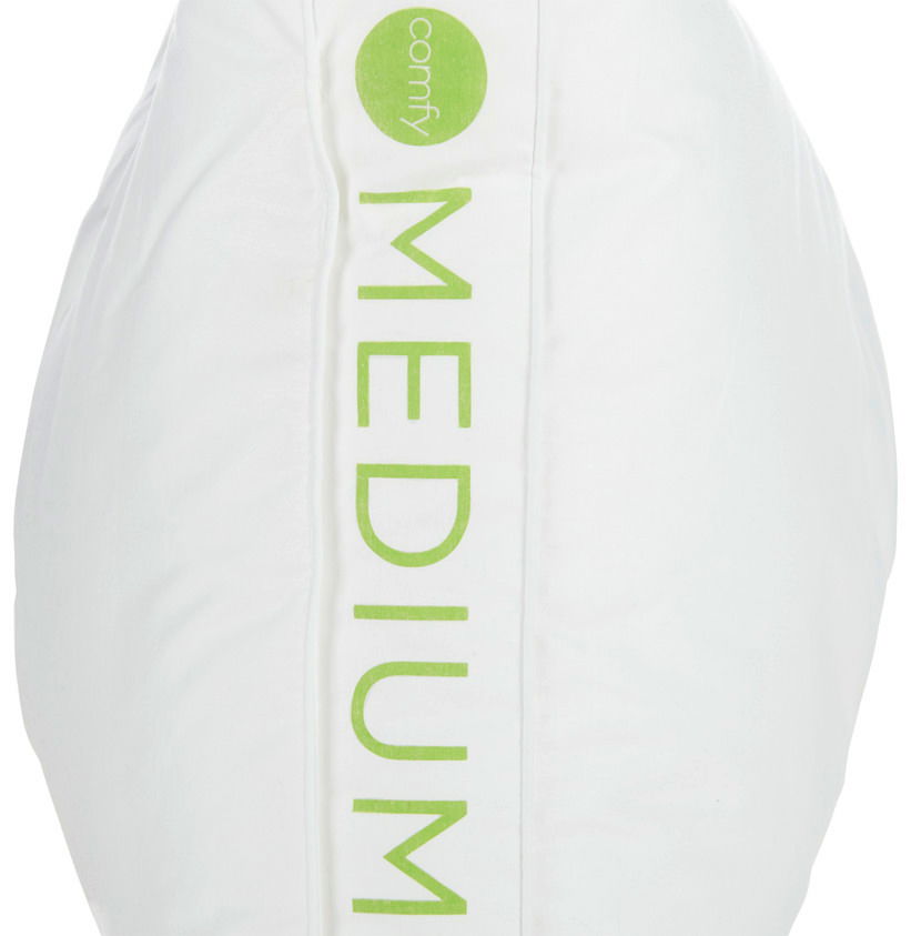 Nahaufnahme eines weißen Kopfkissens mit grünem Aufdruck 'MEDIUM' und 'comfy' von der Seite.
