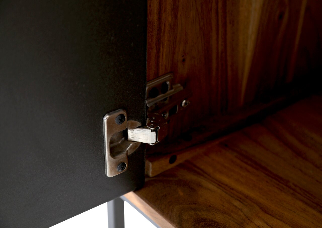 Nahaufnahme eines Scharniers an einem Lowboard aus Holz und Metall, von innen betrachtet.