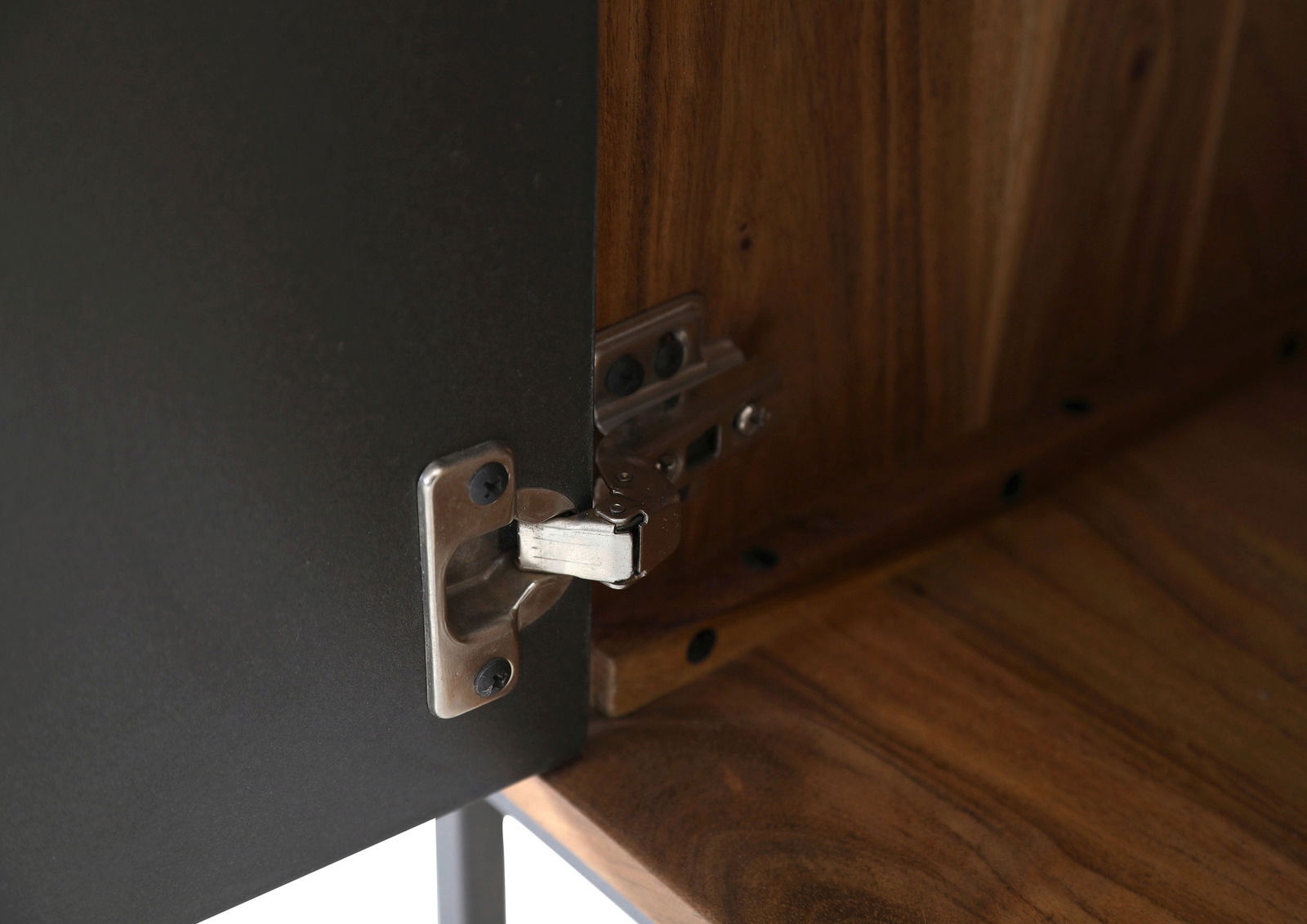 Nahaufnahme eines Scharniers an einem Lowboard aus Holz und Metall, von innen betrachtet.