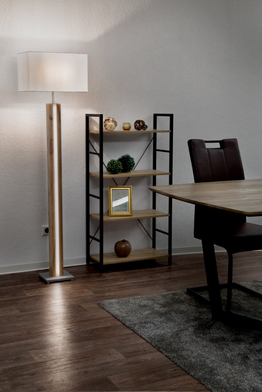 Stehleuchte FOREST in einem modernen Wohnzimmer, seitliche Perspektive, mit einem rechteckigen weißen Lampenschirm und einem Holzständer.