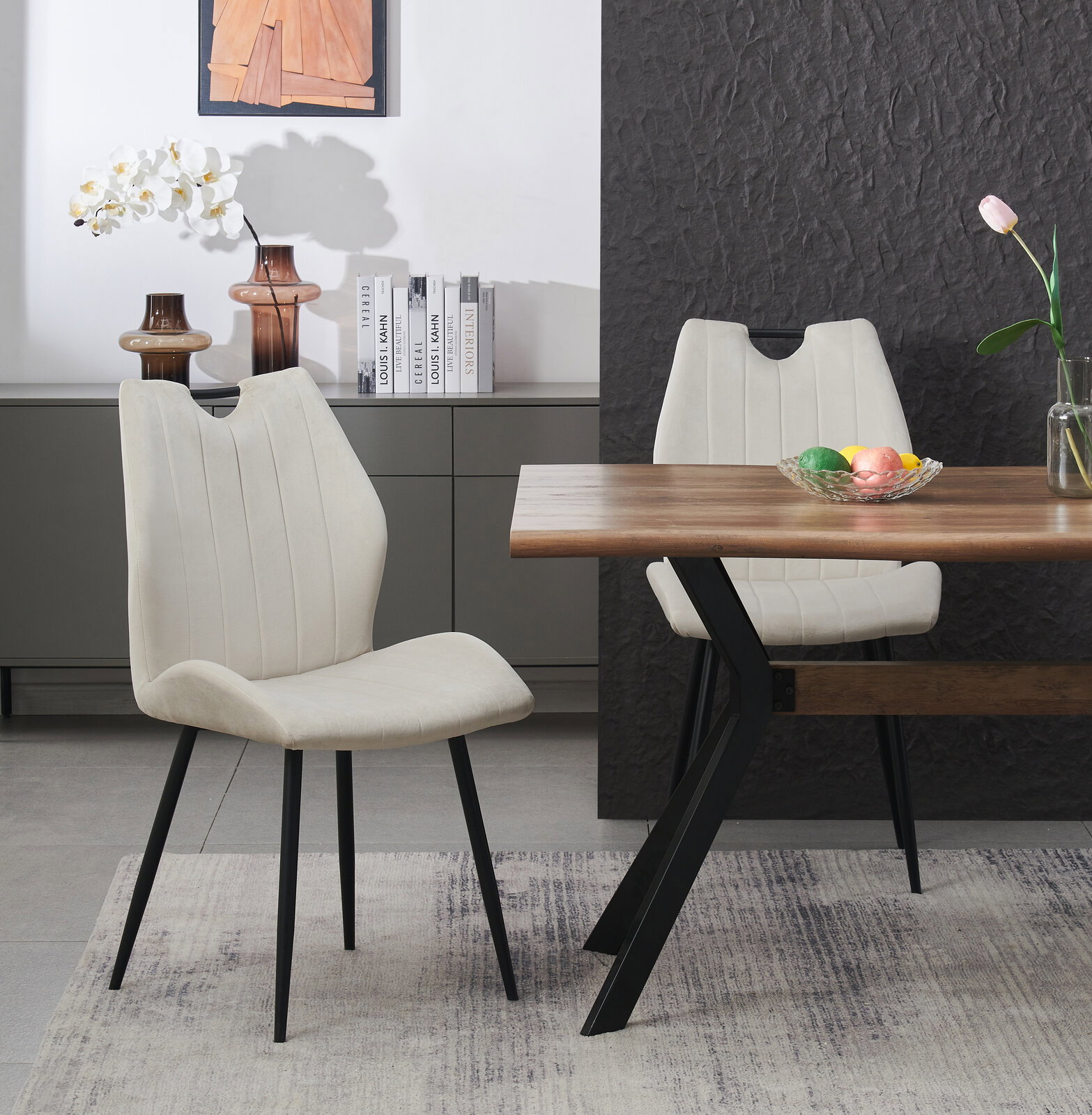 Moderner Esszimmerstuhl mit hellbeigem, vertikal gestepptem Polster und schwarzen Metallbeinen, schräg von vorne im Essbereich neben Holztisch fotografiert