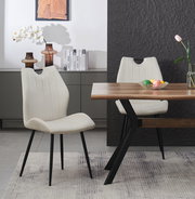 Moderner Esszimmerstuhl mit hellbeigem, vertikal gestepptem Polster und schwarzen Metallbeinen, schräg von vorne im Essbereich neben Holztisch fotografiert