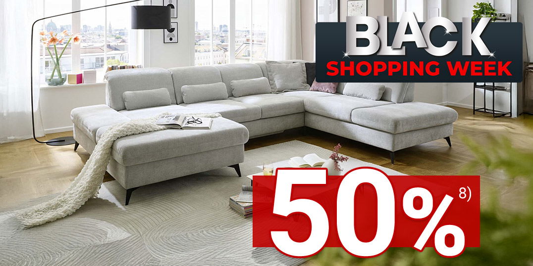 Modernes Wohnzimmer mit heller Eckcouch und großem Fenster, darüber Schriftzug „Black Shopping Week