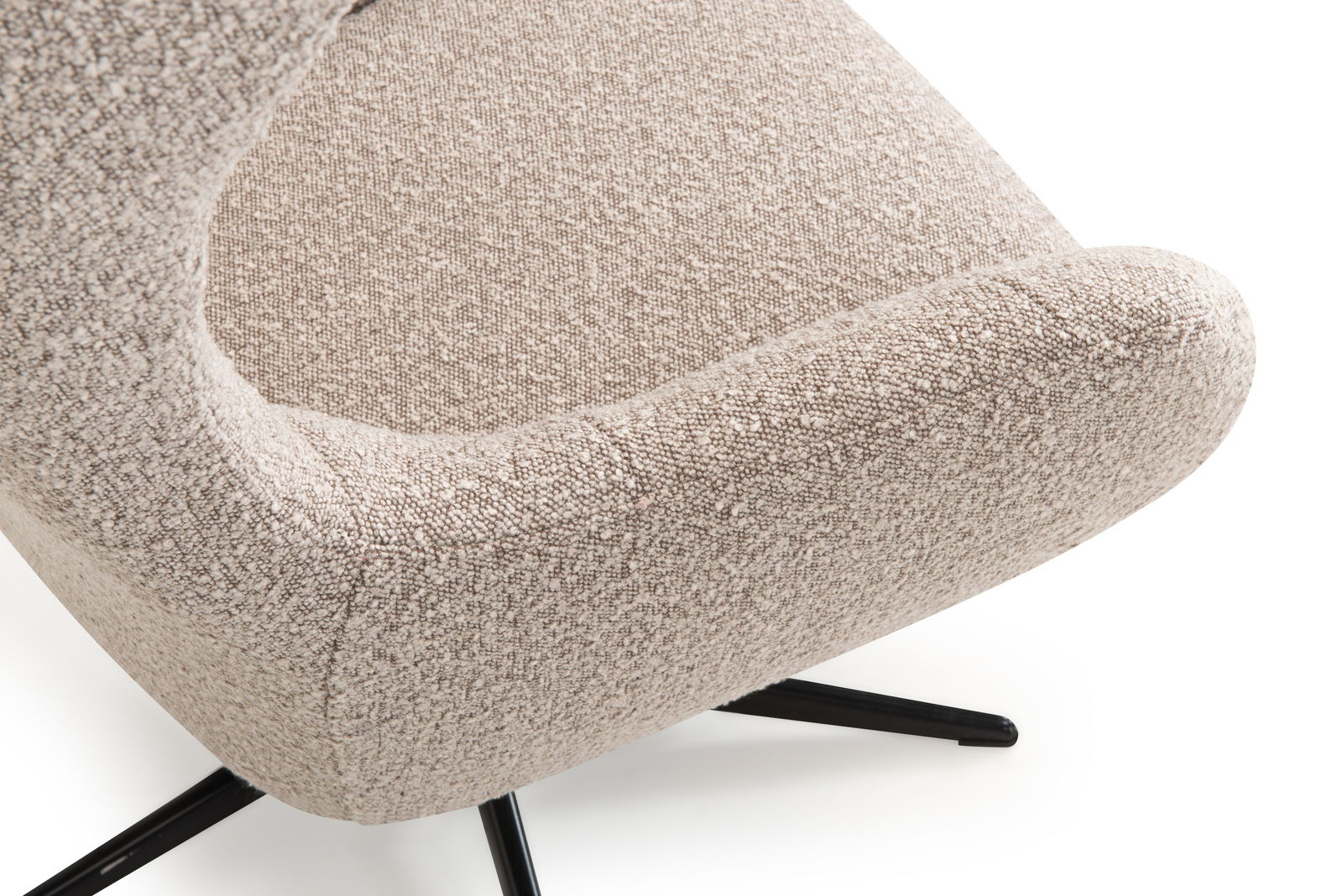 Nahaufnahme eines beige gepolsterten Relaxsessels mit schwarzem Metallfuß, seitliche Perspektive
