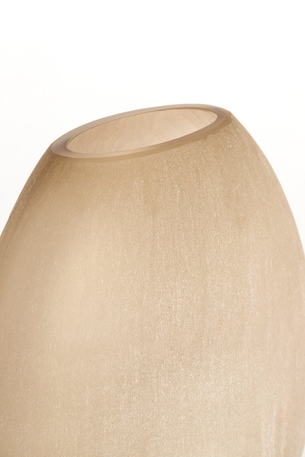 Nahaufnahme einer sandfarbenen Vase mit glatter Oberfläche, von oben betrachtet.