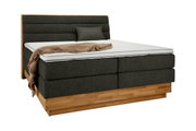 Boxspringbed met donkergrijze stoffen bekleding, houten onderstel en hoofdeinde, zijaanzicht