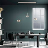 Moderne Pendelleuchte Q-ROTATE in einem stilvollen Esszimmer, seitliche Perspektive.