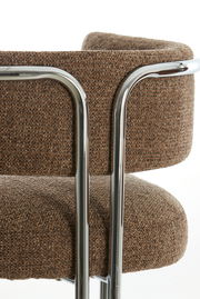 Nahaufnahme eines Armlehnstuhls mit braunem Stoffbezug und verchromtem Metallrahmen, seitliche Perspektive.