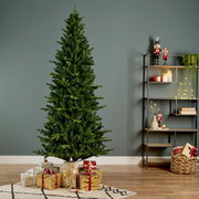 Künstlicher Weihnachtsbaum in einem Wohnzimmer, umgeben von Geschenken, mit seitlicher Perspektive.