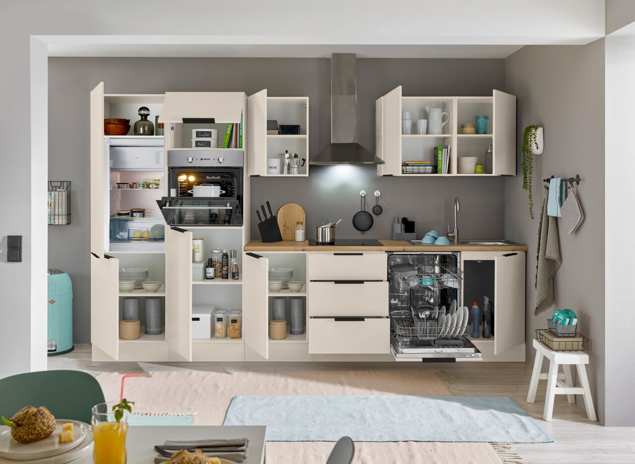 Moderne Küchenzeile mit offenen Schränken, eingebautem Ofen, Kühlschrank und Geschirrspüler, aus der Frontansicht fotografiert.