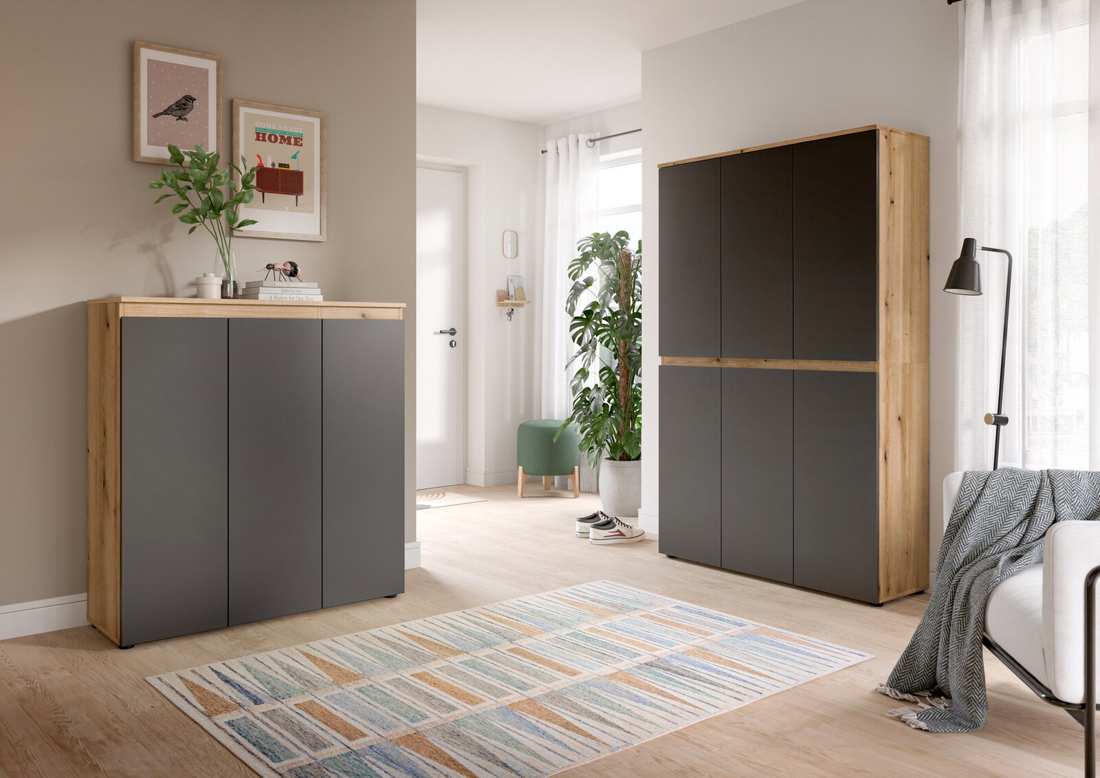 Modernes Sideboard und hoher Schrank in Eiche-Optik mit anthrazitfarbenen Fronten im hellen Wohnzimmer, frontale Perspektive.