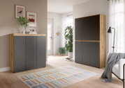 Modernes Sideboard und hoher Schrank in Eiche-Optik mit anthrazitfarbenen Fronten im hellen Wohnzimmer, frontale Perspektive.