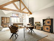 Esszimmer mit Holzbalkendecke, Esstisch und Stühlen im Vordergrund, umgeben von Vitrinen und Sideboards aus Holz und Metall, seitliche Perspektive.