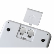 Rückansicht einer digitalen Küchenwaage mit geöffnetem Batteriefach und sichtbaren Knopfzellenbatterien.