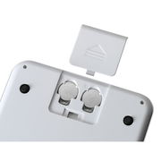 Rückansicht einer digitalen Küchenwaage mit geöffnetem Batteriefach und sichtbaren Knopfzellenbatterien.