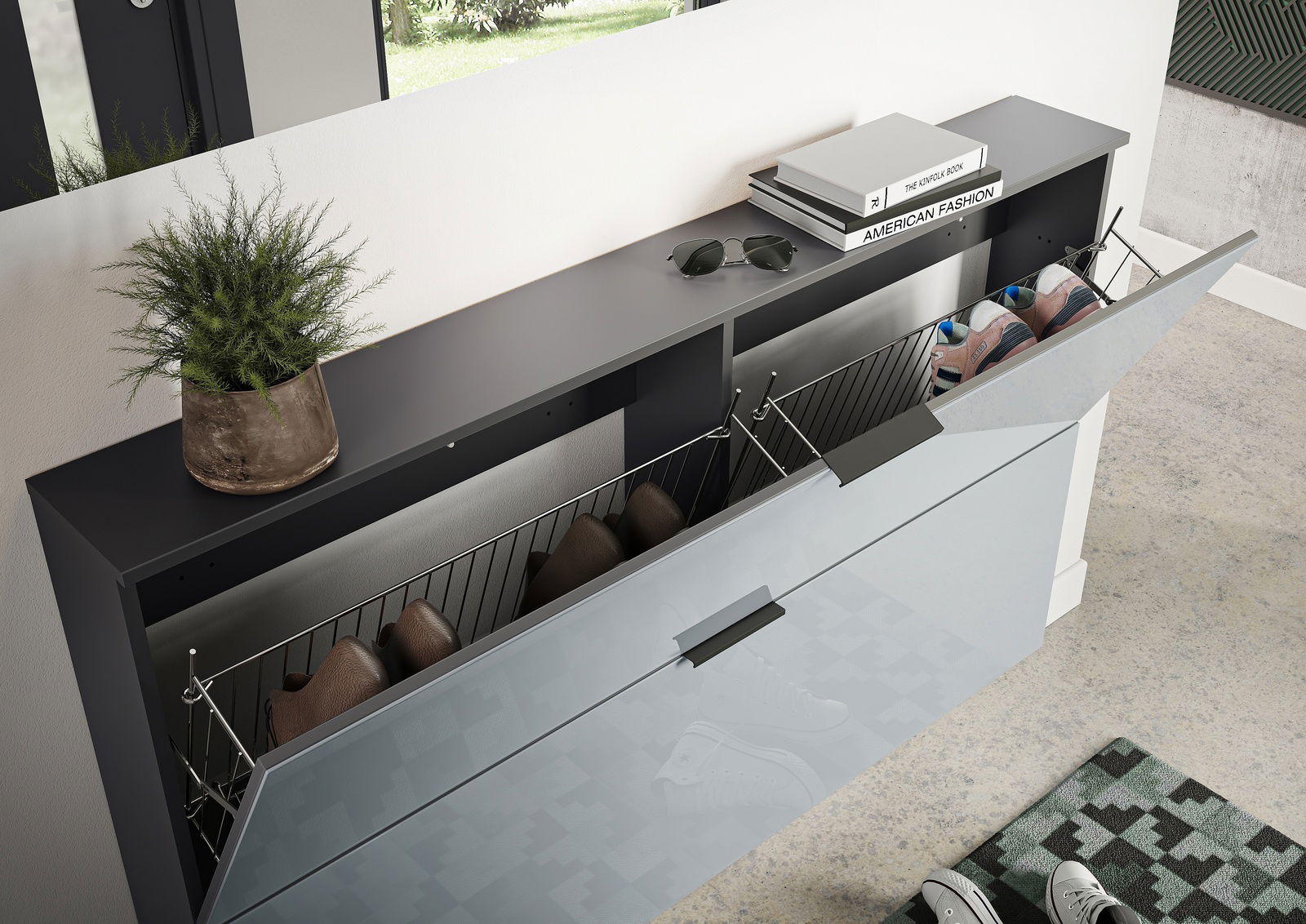 Moderner Schuhschrank in dunklem Design mit geöffneter Klappe, zeigt mehrere Paar Schuhe. Draufsicht mit Dekorationen wie Pflanze und Bücher auf der Oberseite.