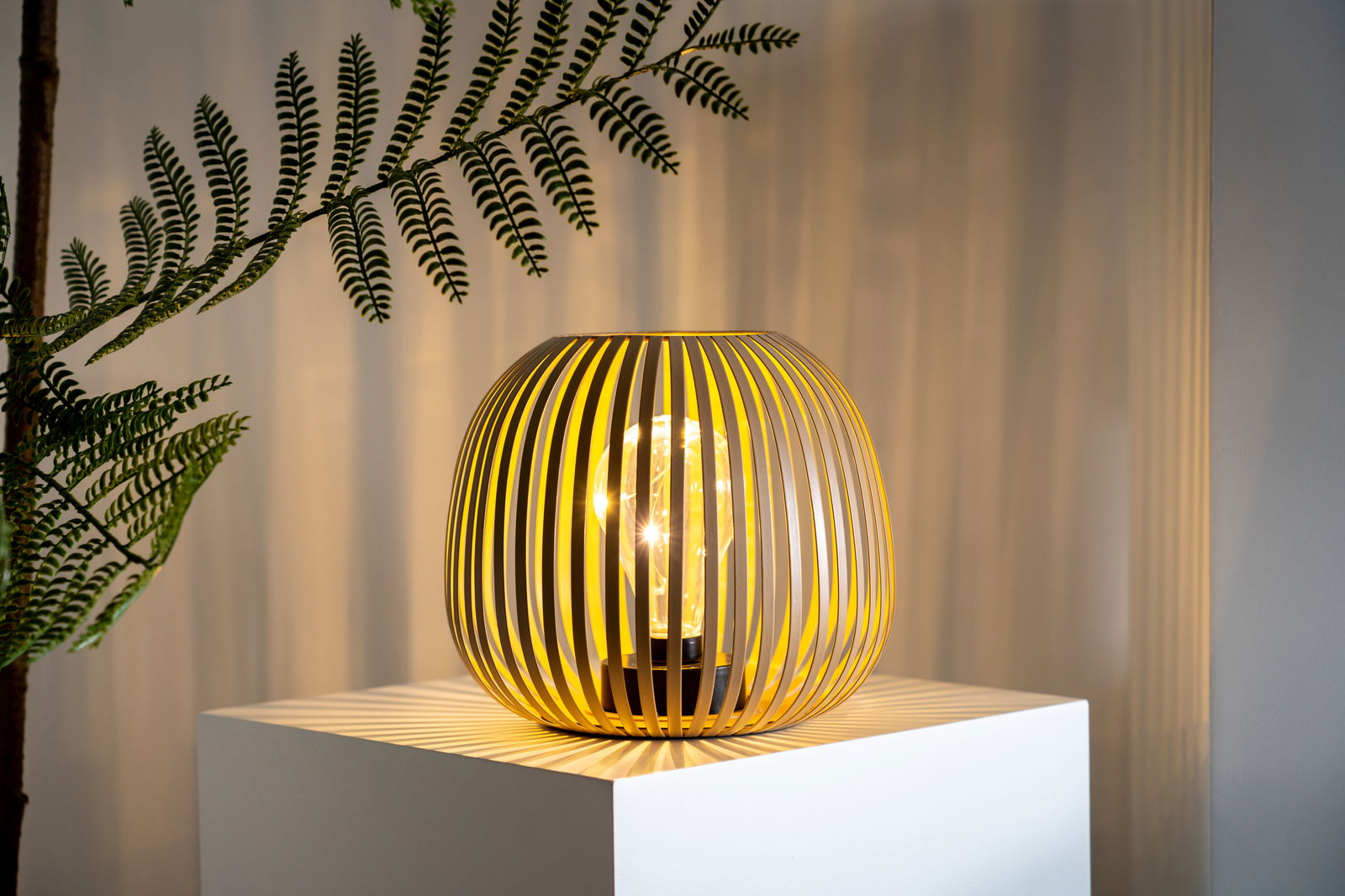 Moderne Solarleuchte mit elegantem, lamellenartigem Design auf einem Podest, seitliche Perspektive