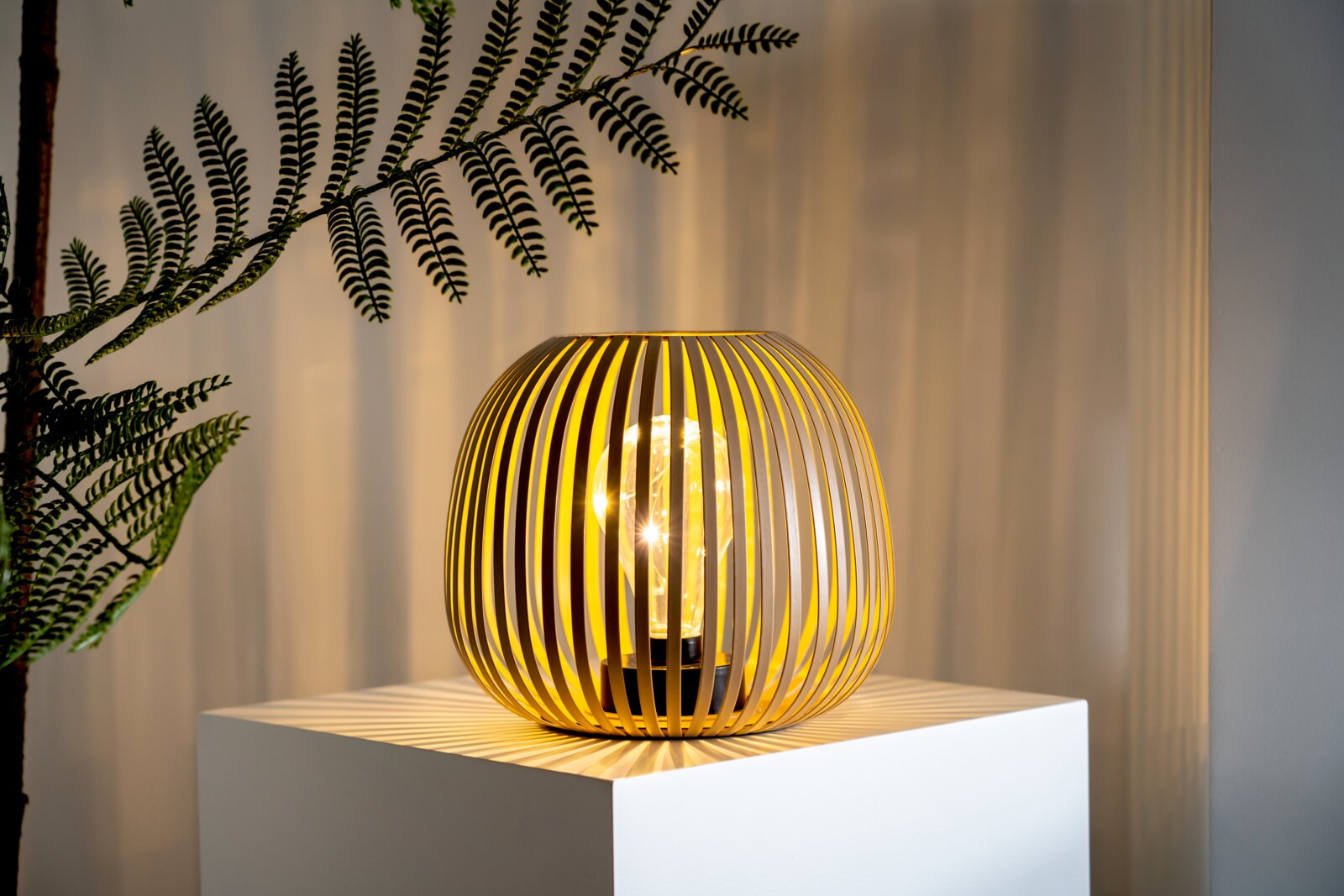 Moderne Solarleuchte mit elegantem, lamellenartigem Design auf einem Podest, seitliche Perspektive