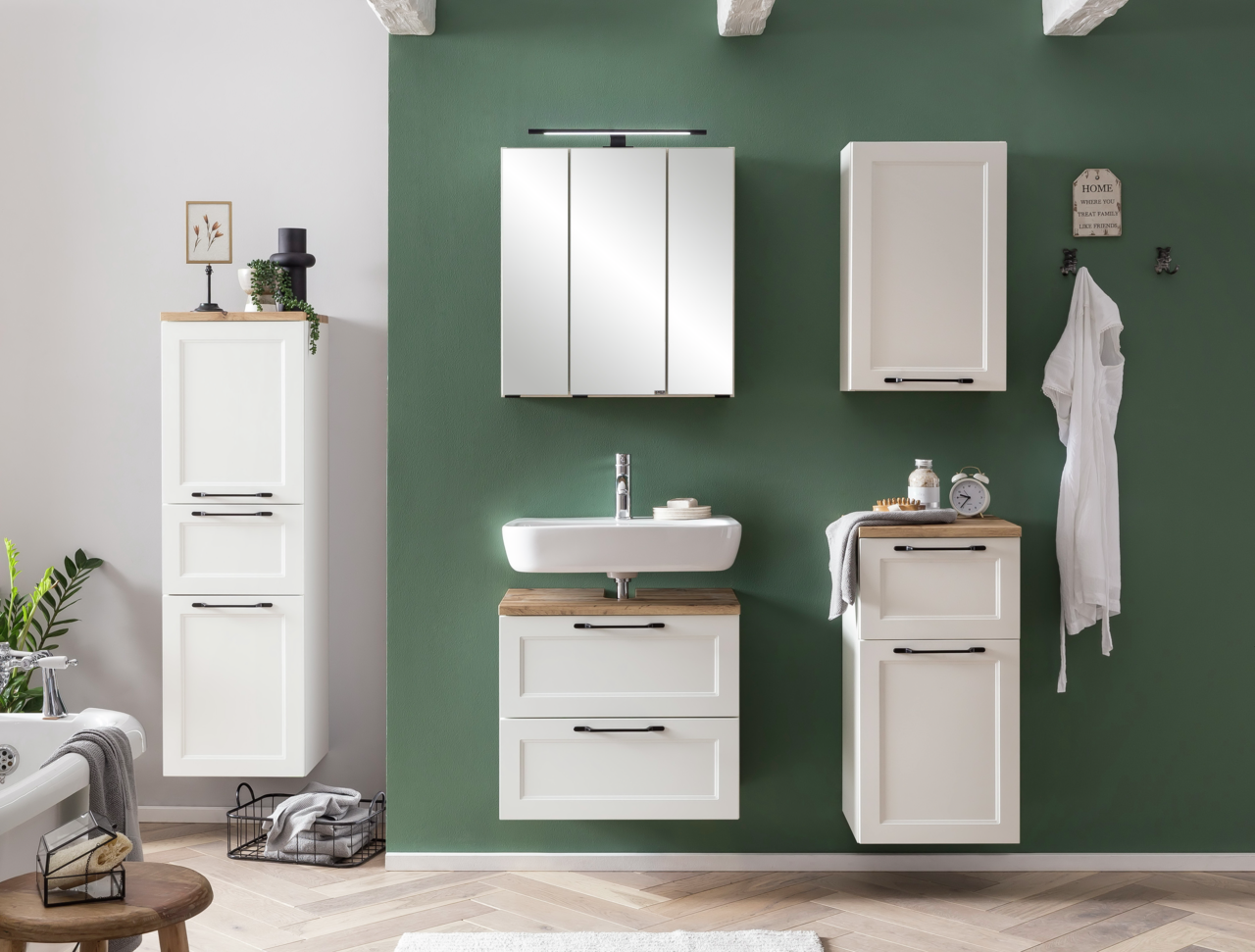 Moderner weißer Midischrank in einem stilvollen Badezimmer, frontal betrachtet, mit grüner Wand im Hintergrund.