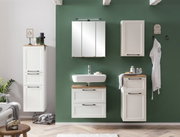 Moderner weißer Midischrank in einem stilvollen Badezimmer, frontal betrachtet, mit grüner Wand im Hintergrund.