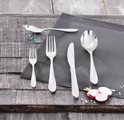 Besteckset bestehend aus Messer, Gabel, Löffel und Teelöffel auf einem grauen Platzdeckchen, von oben fotografiert.